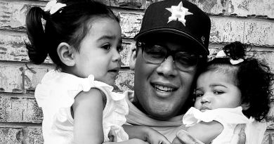 Michael Cartagena holding his two young children in his arms