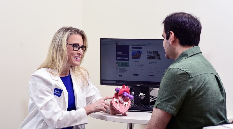A doctor showing a model heart to a patient