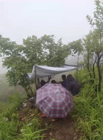 Clinicians gather around a phone in remote location for virtual surgical education with Global Trauma Collaboration